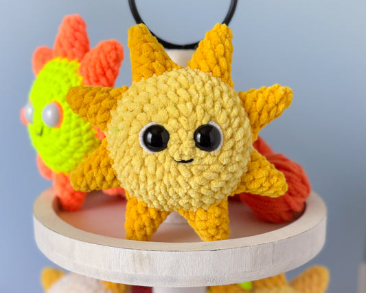 Crocheted sunshine on a wooden stand with a plain background