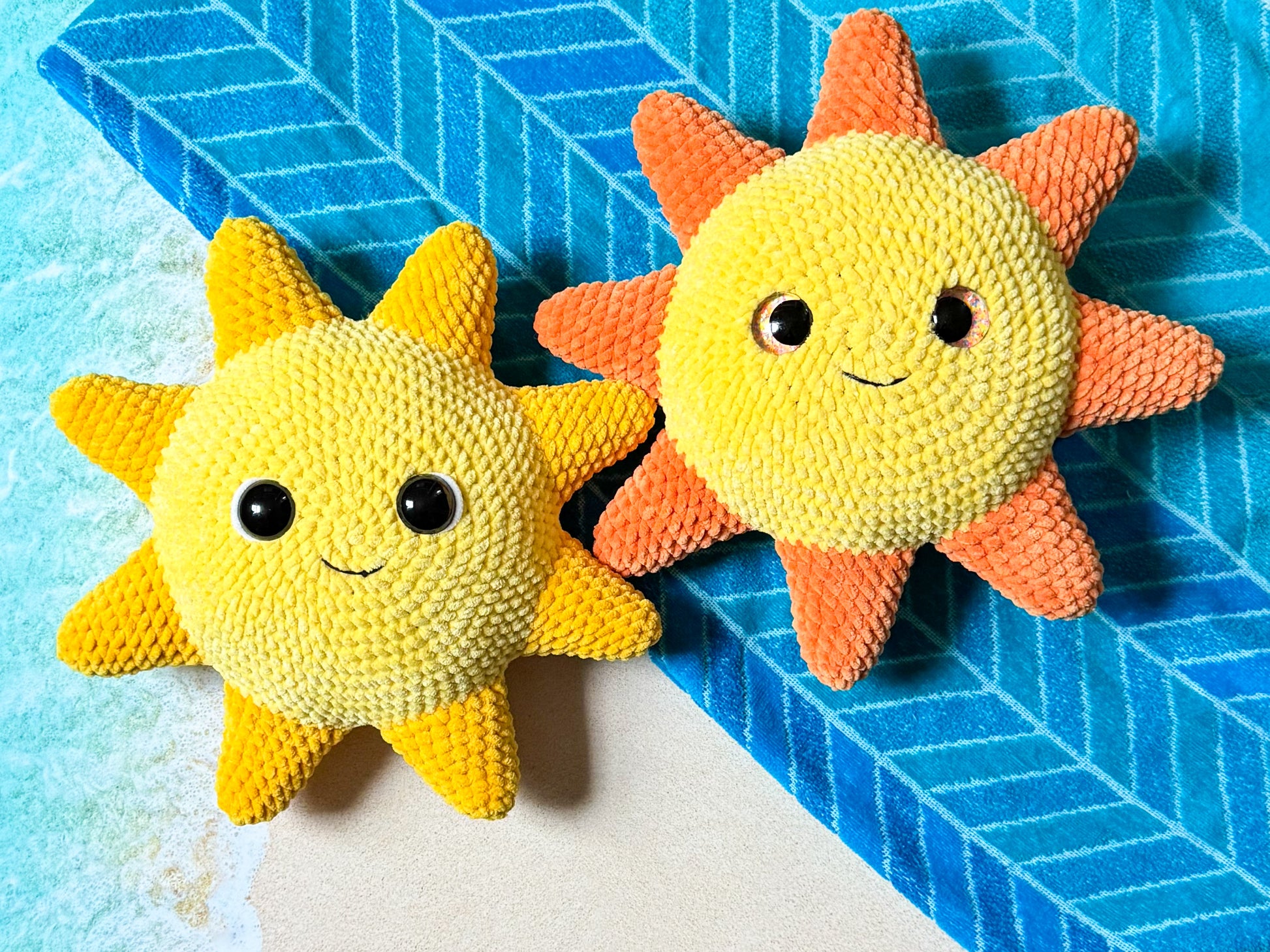 Two sun-shaped plush toys on a blue textured surface